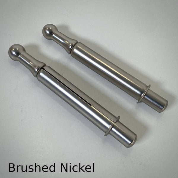 Pair of brushed nickel window sash spring bolts featuring a subtle satin silver metallic texture.