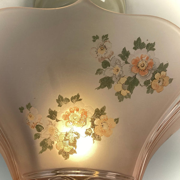 Close-up detail of the orange, yellow, and white floral transfer print on the frosted pink glass shade.