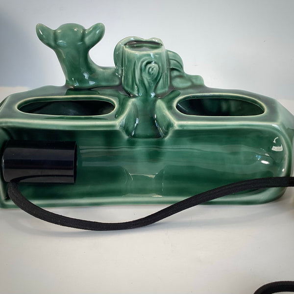 Rear view of the green ceramic lamp showing the bulb socket, internal wiring, and dual planter openings.