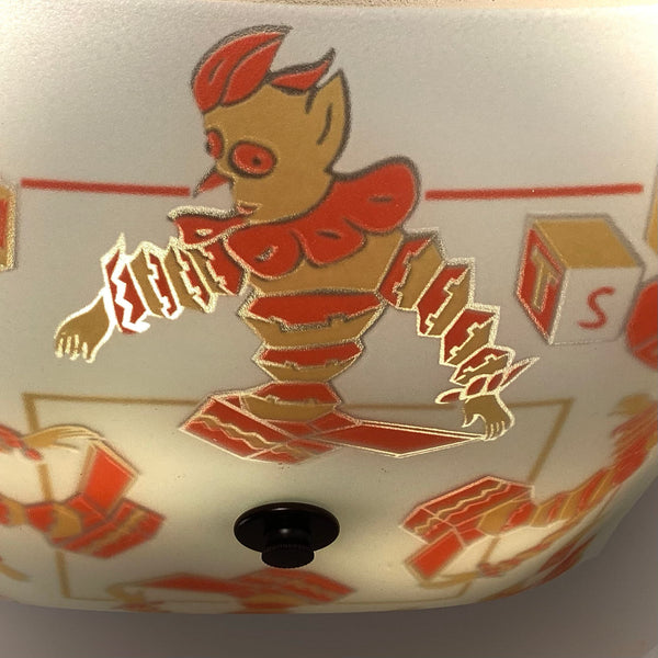 Close-up detail of the vintage nursery clown graphic on a frosted glass light shade with warm internal lighting.