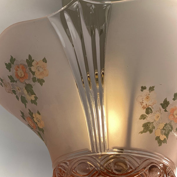 Close-up side profile showing the clear glass vertical ribs and floral transfer design on the pink shade.