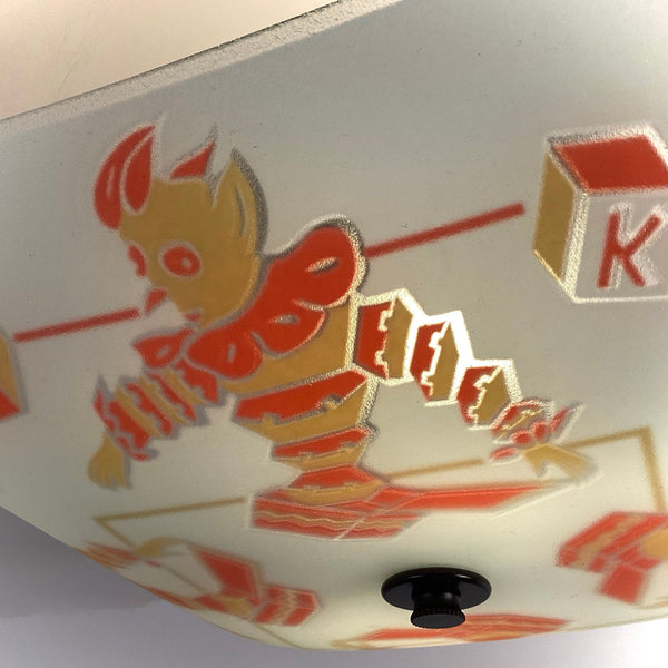 Detailed unlit shot of the painted red and yellow jack-in-the-box clown figure on frosted glass.