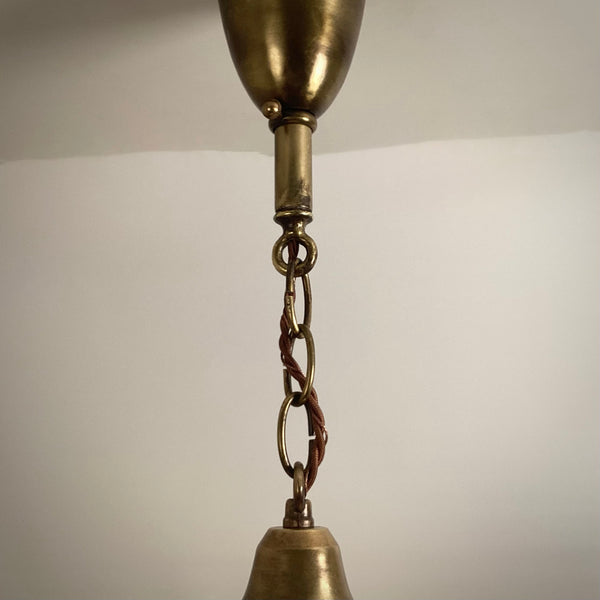 Brass chain link suspension hardware with twisted brown electrical cord.