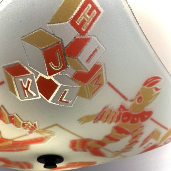 Close-up macro view of the alphabet blocks depicting letters J, K, L, and M on the vintage light shade.