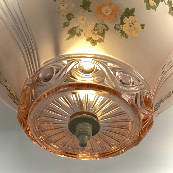 Close-up of the molded circular pattern on the bottom base of the pink glass fixture with the lower finial.