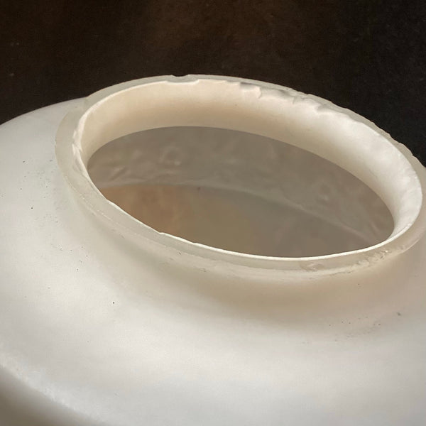 Close-up view of the top opening and fitter lip of a frosted white glass lamp shade.