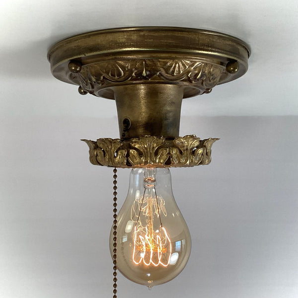 Antique Brass Flush Mount Ceiling Light with Pull Chain. The fixture has been rewired, cleaned, and detailed and retains much of its aging and wear. It also includes the hardware for easy installation. Available at www.vintporium.com