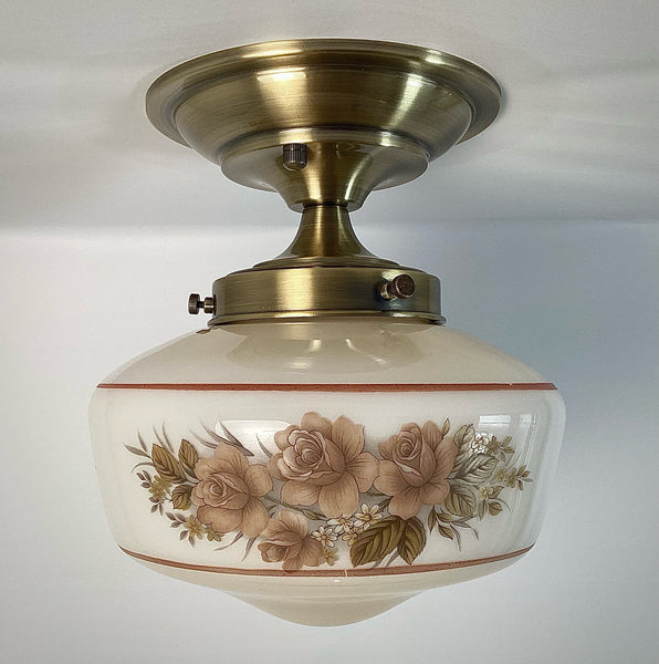 This semi-flush ceiling light features a vintage 1970s glass shade that combines hand-painted bands and a screen-printed floral motif. Screen printing is a technique widely used for applying designs and patterns onto various surfaces, including glass. In the 1970s, this method gained popularity due to its versatility and ability to produce high-quality, durable prints. Available at www.vintporium.com