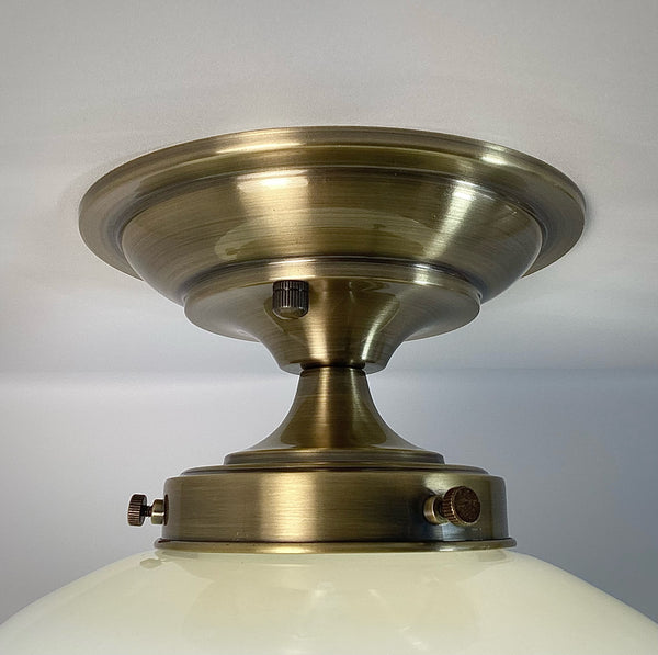 This semi-flush ceiling light features a vintage 1970s glass shade that combines hand-painted bands and a screen-printed floral motif. Screen printing is a technique widely used for applying designs and patterns onto various surfaces, including glass. In the 1970s, this method gained popularity due to its versatility and ability to produce high-quality, durable prints. Available at www.vintporium.com