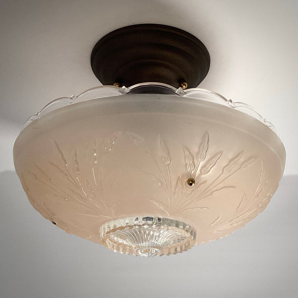 Unlit antique frosted glass ceiling light fixture showing a dark bronze canopy and detailed botanical relief pattern.