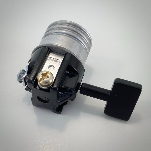 Side view of Leviton 3-way lamp socket interior showing metal contact strip marked MEXICO and brass terminal screw.