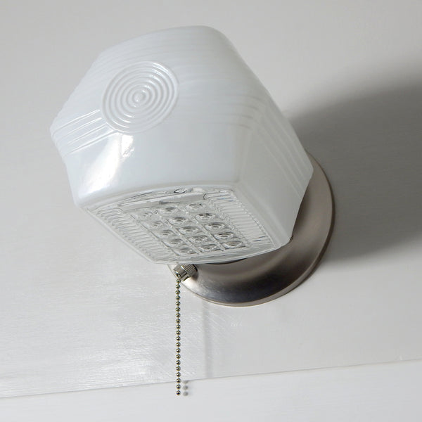 Side view of mid-century enameled glass wall sconce with satin nickel mount and classic concentric ring design.