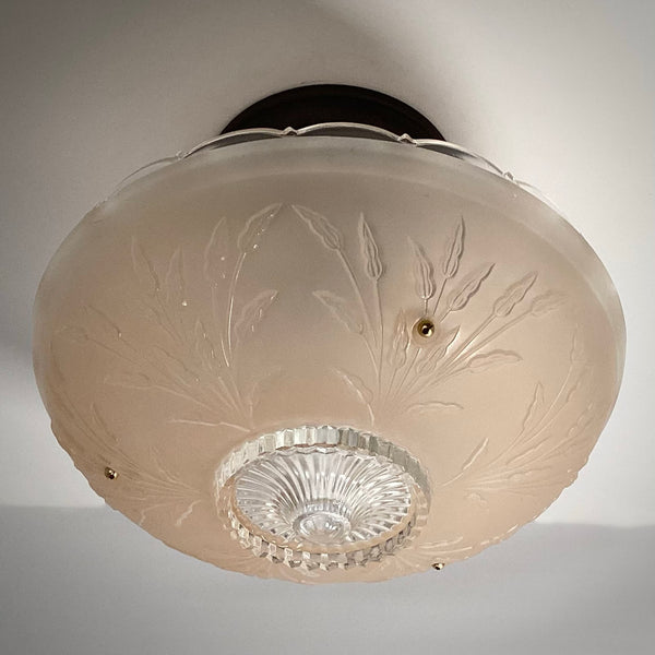 Bottom perspective of an unlit vintage frosted glass lamp shade featuring a fluted center starburst and brass hardware.