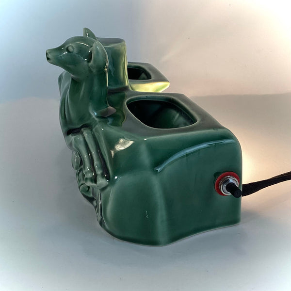 Side profile of the green ceramic doe lamp highlighting the sleek Mid-Century silhouette and toggle switch.