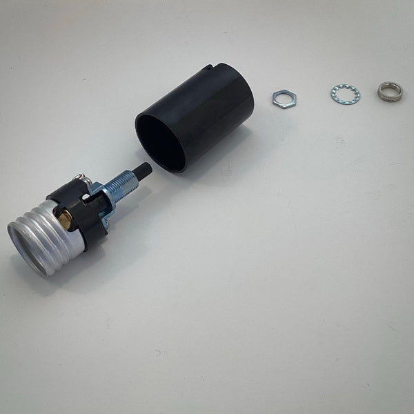 Exploded view of a disassembled Sun-Lite Bakelite lamp socket showing the metal interior terminal shell, outer black phenolic sleeve, hex nut, lock washer, and knurled collar.