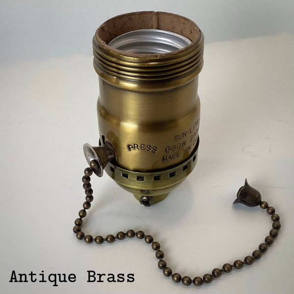 Antique brass UNO pull-chain socket with aged patina and darkened brass chain.