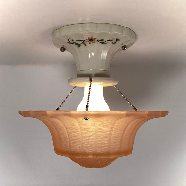 Side view of peach pressed glass Art Deco shade mounted to porcelain canopy