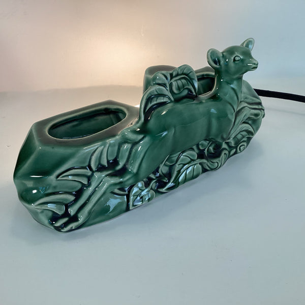 Three-quarter view of the vintage deer lamp showing the high-gloss green drip glaze and molded leaf details.