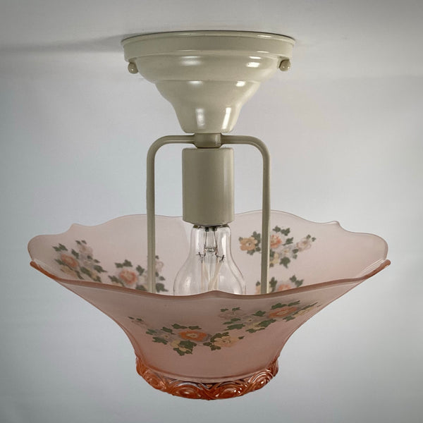 Internal view showing the clear lightbulb and mounting bracket inside the unlit pink glass shade.