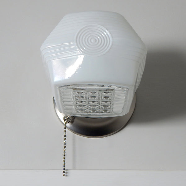 Enameled glass wall light with soft white glow and satin nickel base, inspired by 1940s streamline design.