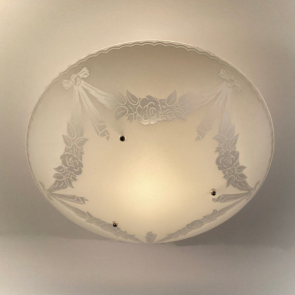 Bottom view of vintage 1950s semi flush ceiling light showing frosted glass bowl with enamel floral and ribbon garland pattern