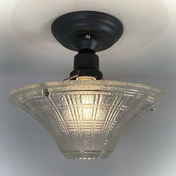 lit vintage pressed glass ceiling light glowing warmly with new charcoal mount