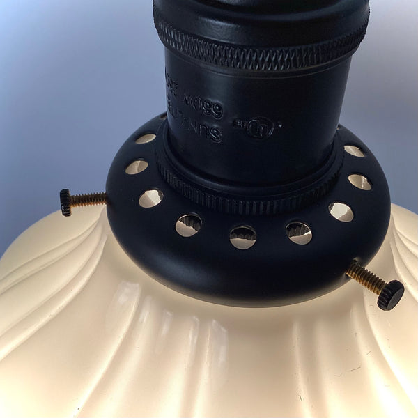 Detail shot of a black industrial-style light socket and shade fitter with screws.