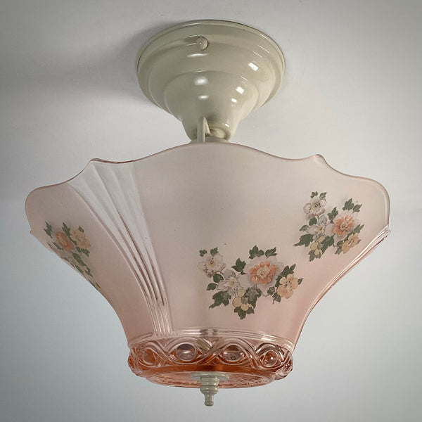 Side view of the unlit pink frosted glass flush mount light fixture attached to a white ceiling canopy.