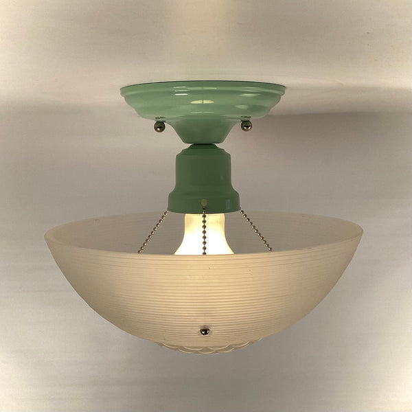 Exposed bulb and jadeite-green fitter with ribbed glass shade held by bead chains