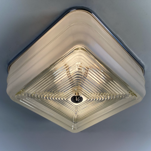 Mid-century square ceiling light with aluminum fixture base and stepped concentric glass diffuser, illuminated view — Vintporium