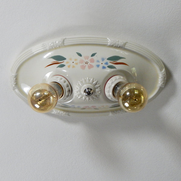 The vintage 1930s porcelain ceiling light has uranium glass glazed highlights and a delightful glazed floral stenciled pattern. The fixture has been restored and features new wiring and sockets, etc. The fixture has been cleaned, detailed, and is ready to install. Available at www.vintporium.com