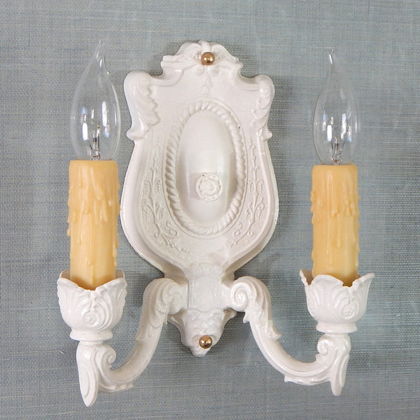 The shabby chic style is characterized by its old-fashioned charm and unique distressed details. This delightfully handsome antique Art Kast sconce embraces its shabby chic look with a blend of canvass white paint, over a pot petal cast body, and honey-colored poly wax candelabra covers. The fixture has been renovated with new sockets, wires, mounting hardware, etc. making it convenient to install. Available at www.vintporium.com